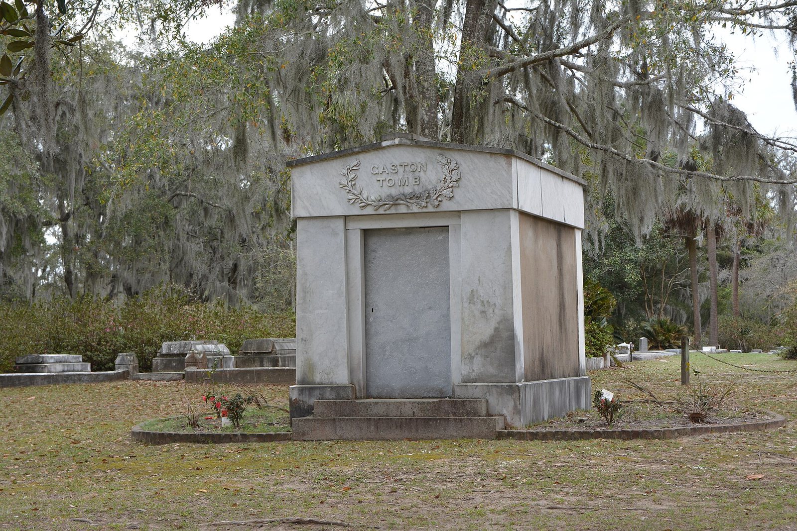 A marble family tomb under live oaks hung with Spanish moss at Bonaventure Cemetery