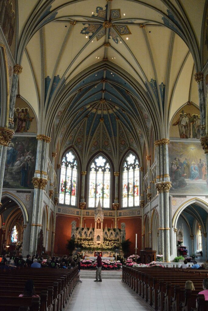 The soaring Gothic nave of the Cathedral Basilica of St. John the Baptist in Savannah, with painted vaults and stained glass