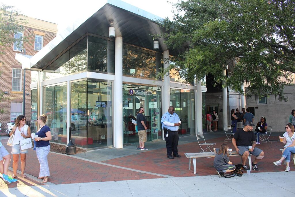 Families and visitors outside the glass visitor center pavilion in Ellis Square, Savannah