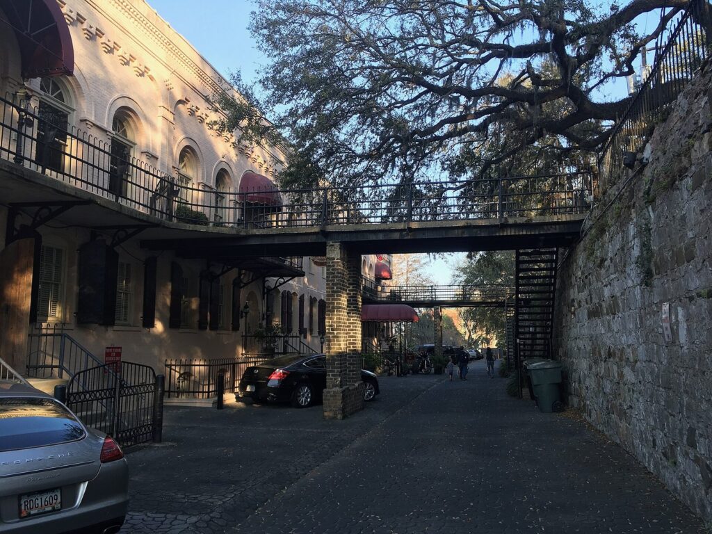 Iron footbridges and brick buildings along the cobblestone lane of Factors Walk below Bay Street