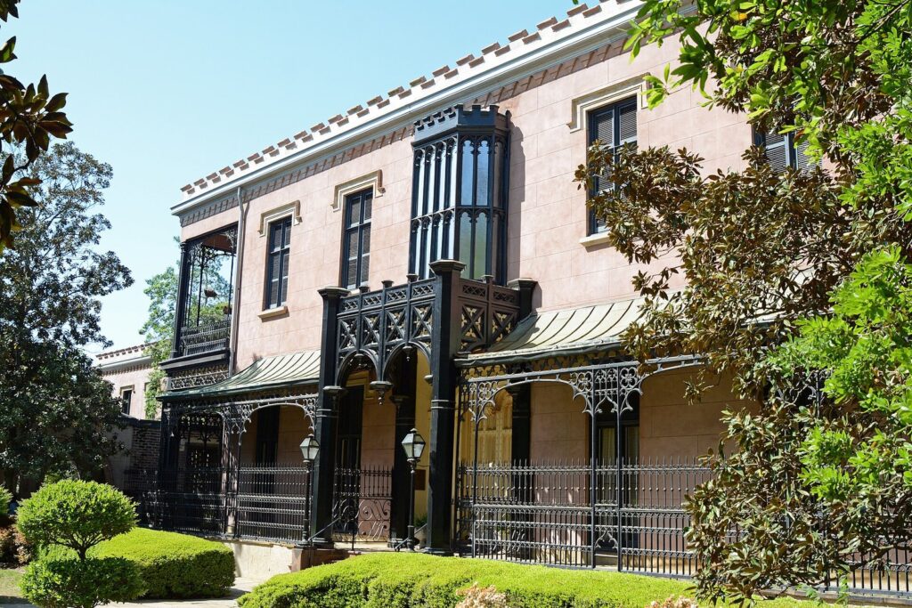 The Gothic Revival Green-Meldrim House in Savannah, with pale walls, crenellated roofline and ornate iron porch
