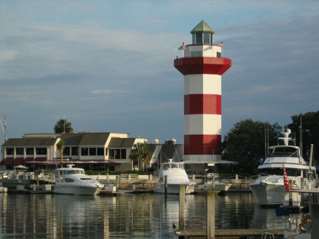 The red and white striped Harbour Town lighthouse beside a marina full of boats on Hilton Head Island