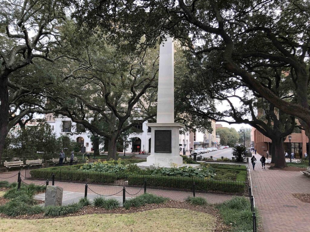 Savannah Historic District guide: the obelisk monument in Johnson Square under live oaks, with Bull Street beyond