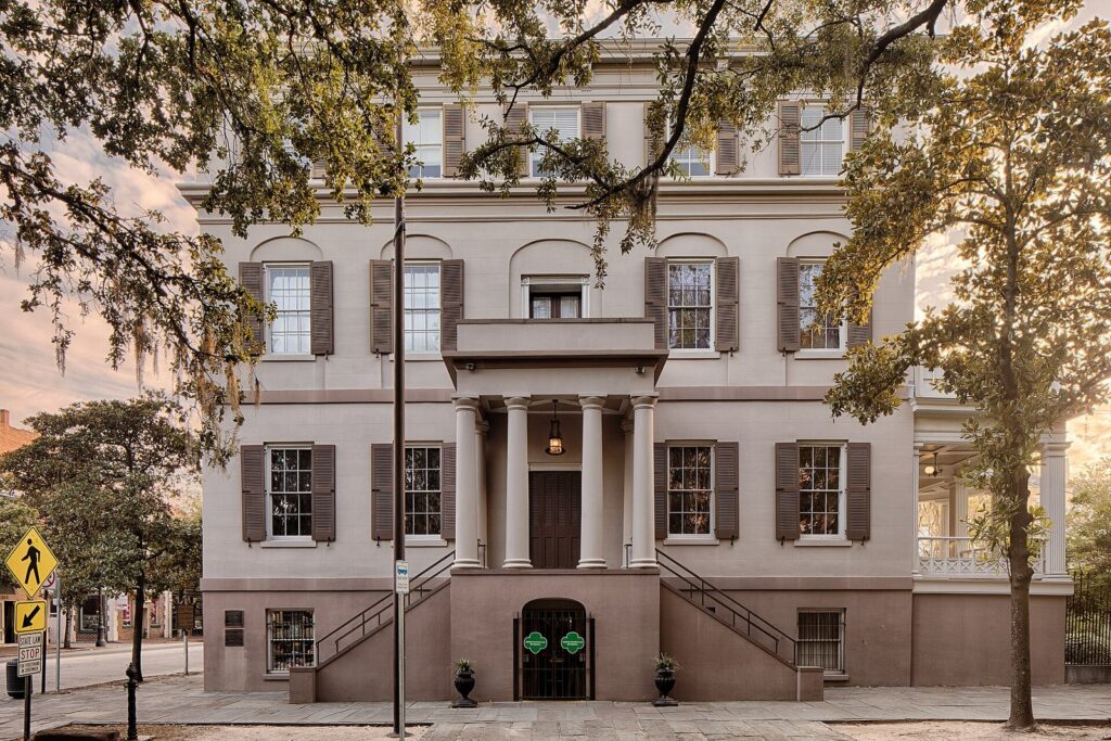 The pale stucco facade and double stairs of the Juliette Gordon Low Birthplace in Savannah