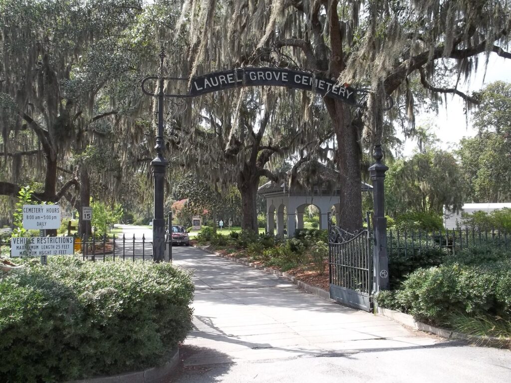 The iron arch over the entrance to Laurel Grove Cemetery in Savannah, under live oaks hung with Spanish moss