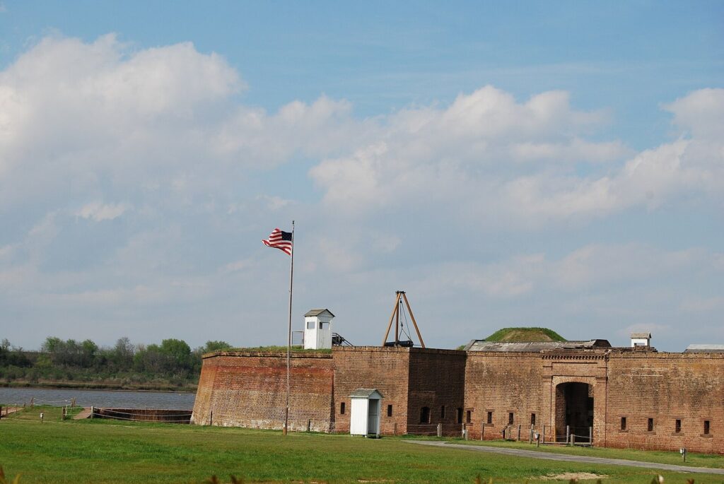 The brick walls and gate of Old Fort Jackson beside the Savannah River, with an American flag flying