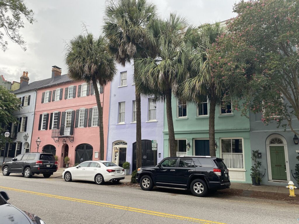 Pastel-painted historic row houses of Rainbow Row in Charleston, South Carolina, with palm trees in front