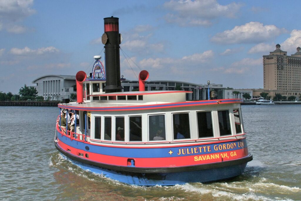 The red and blue Savannah Belles Ferry carrying passengers across the Savannah River