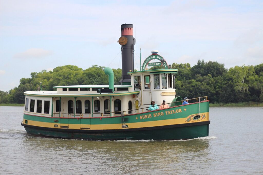 The green and yellow Savannah Belles Ferry Susie King Taylor crossing the Savannah River