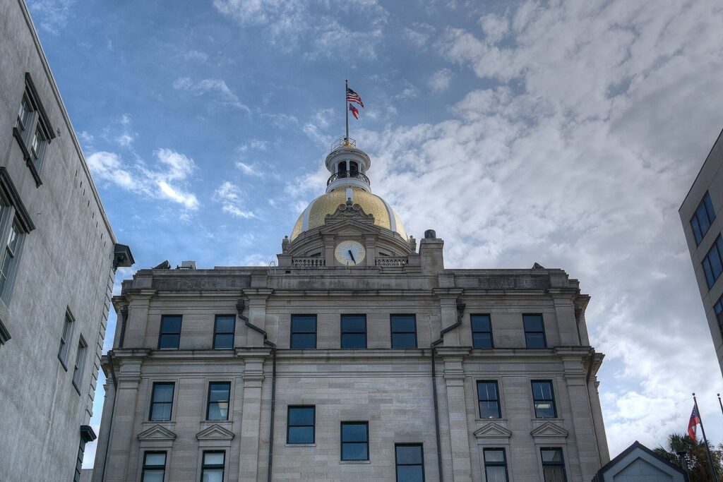 Savannah City Hall and its gold dome on Bay Street under a cloudy sky