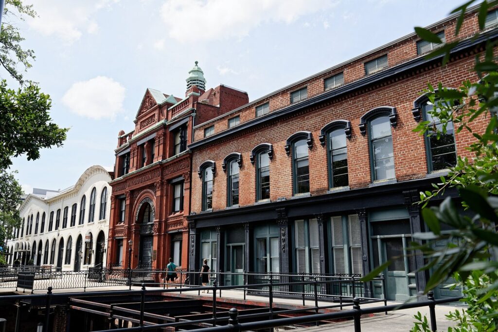 The red brick Savannah Cotton Exchange and the row of brick buildings beside it on Bay Street, seen from Factors Walk