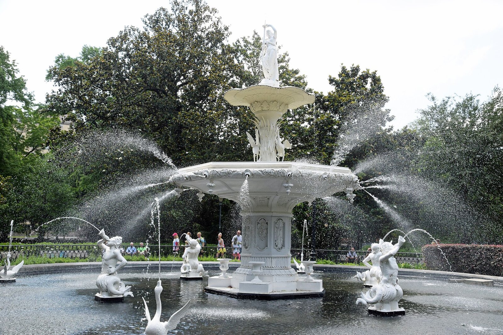 The white cast-iron fountain in Forsyth Park, Savannah, spraying water into its basin under live oaks