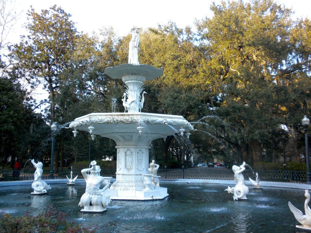 The white cast-iron Forsyth Park fountain framed by live oaks in Savannah