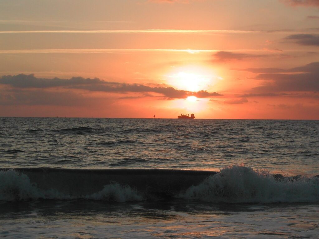 The sun rising over the Atlantic from North Beach on Tybee Island, with a ship on the horizon