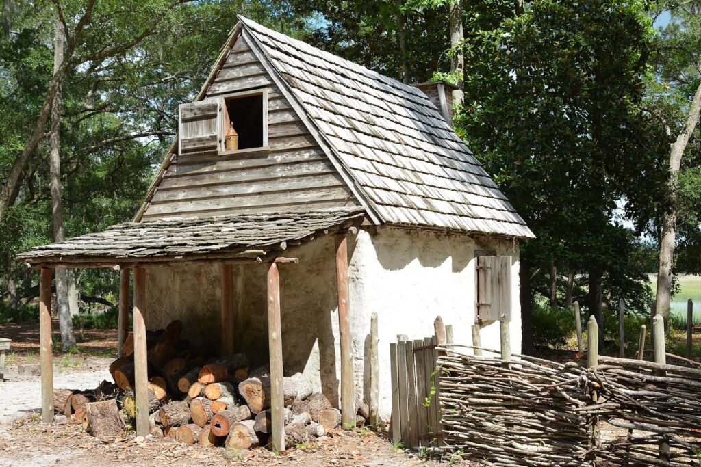 A small whitewashed hut with a wooden shingle roof in the colonial life area at Wormsloe