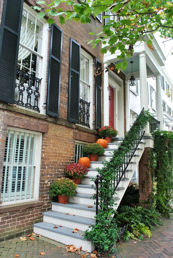 Pumpkins and potted mums on the stone stoop of a brick townhouse on East Gordon Street in Savannah