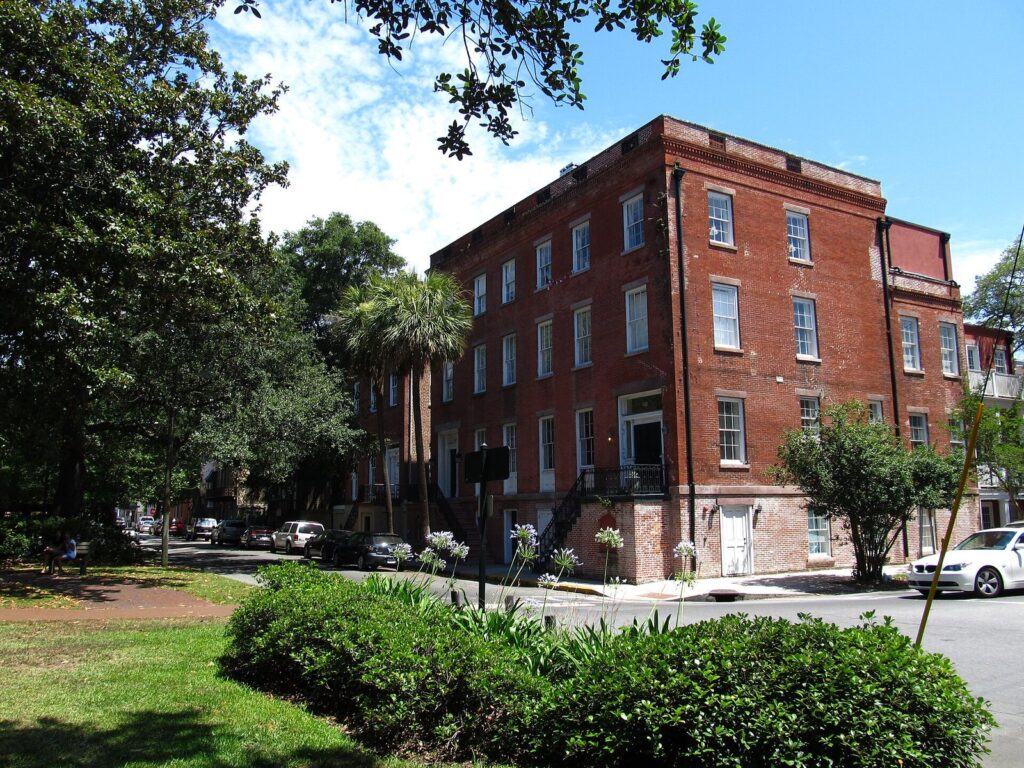 Complete Savannah Historic District visitor guide: a red brick townhouse and live oaks at the corner of York and Abercorn streets on Oglethorpe Square