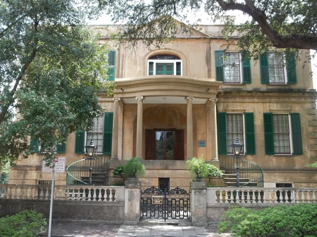 Front facade of the Owens-Thomas House on Oglethorpe Square, Savannah, with green shutters and a columned portico